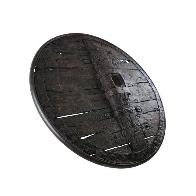 A large plank wagon wheel of Gothic type. The disc is built from heavy boards, held by iron straps and nails, and bound...