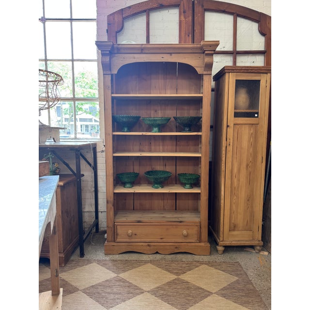 Charming rustic pine bookcase dating to circa 1900, featuring a beautifully shaped cornice, four adjustable interior...