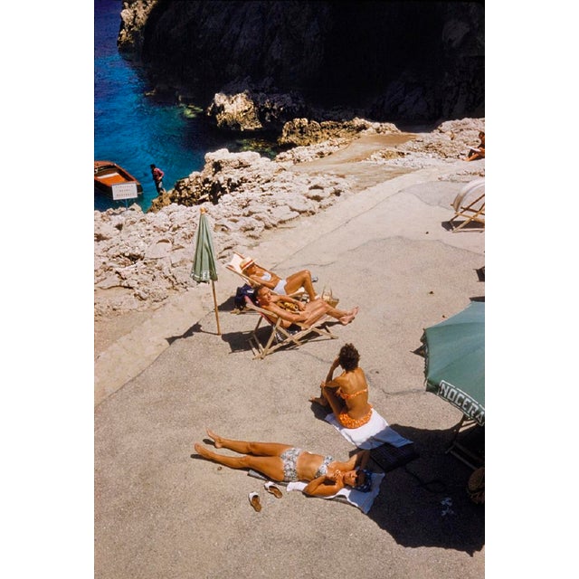 Capri Sun Loungers by Toni Frissell Sunbathers enjoy the view on the coastline of Capri, 1959. (Toni Frissell) Archival...