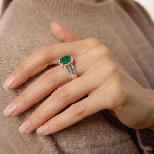A striking and luxurious vintage design, this elegant ring centers on a vivid 3.21 carat oval cut emerald. Its richly...