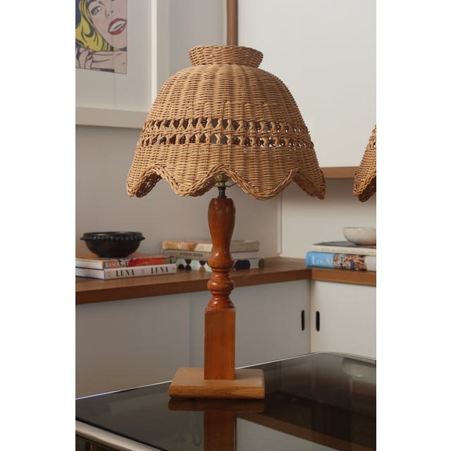Charming pair of vintage table lamps featuring hand-woven wicker shades with a distinctive bell-dome silhouette,...