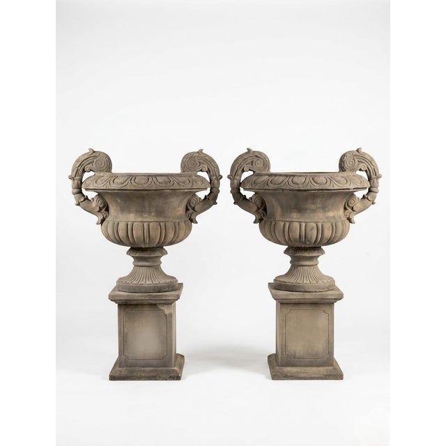 This striking pair of vintage cast stone urns captures the timeless elegance of Neoclassical garden architecture. Each urn...
