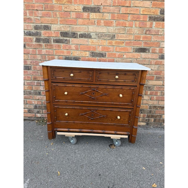 This 19th-century faux bamboo chest with a white marble top is a captivating blend of sophistication and charm. The...