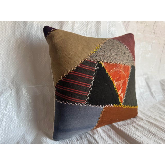 This vintage American patchwork pillow is crafted from a variety of hand-selected fabric remnants, each uniquely stitched...