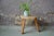 A thick wooden board with uncertain shapes, carried by a tripod base with visible assemblies, this farm stool touches us...