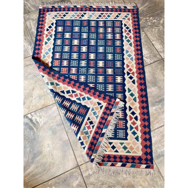 Vintage wool kilim rug, entirely hand-woven on a flatloom during the 1970s and featuring a refined geometric design with a...