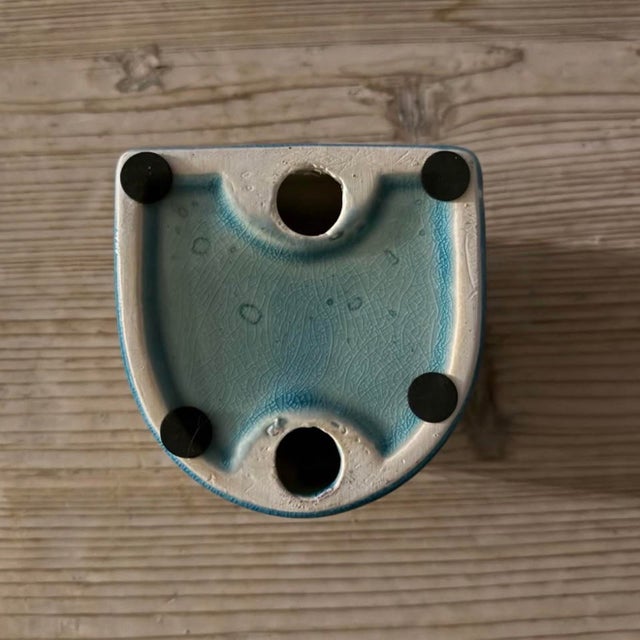 Sculptural artisan ceramic taper candle holder finished in a soft turquoise-blue crackle glaze. The asymmetric form...