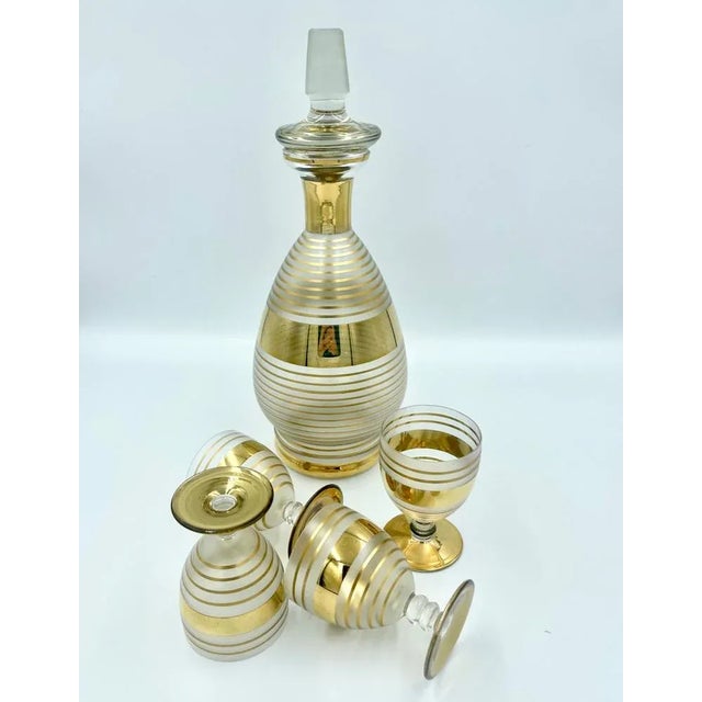 Set of 5 pieces: carafe and four glasses. Dimensions of glasses: 5,5 cm diameter x 8 cm height.