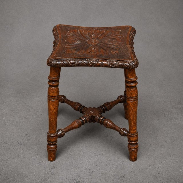 This 19th Century English carved oak stool showcases exceptional craftsmanship and timeless old-world character through...