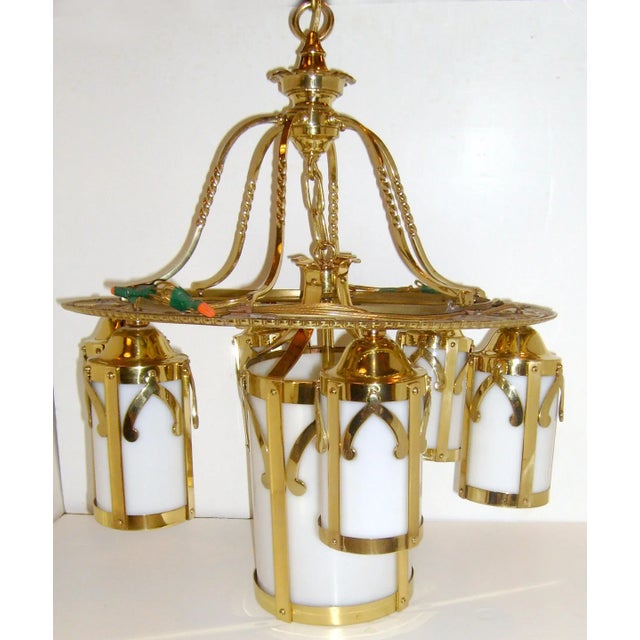 Antique, early 20th century brass chandelier having hanging tube form shades with pointed arch design frames on round...