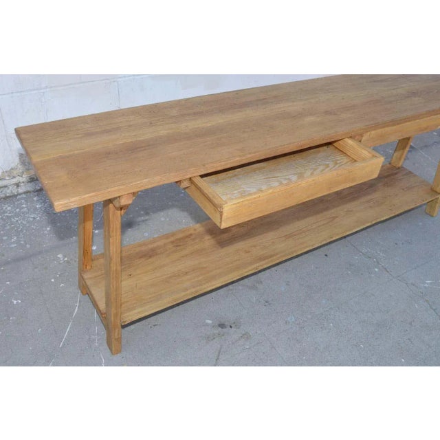 This custom built console table is made using reclaimed, vintage wood. It has a shelf and two drawers that can be opened...