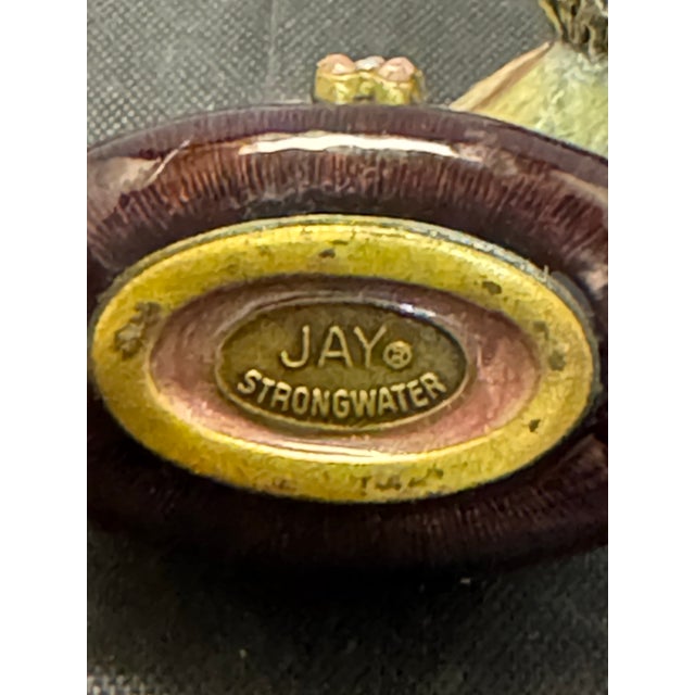 The Jay Strongwater Miniature Bird Enamel Trinket Box is a small, handcrafted collectible item featuring a beautiful...