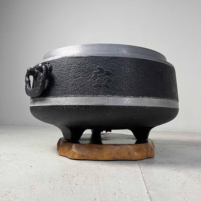 Vintage Japanese metal hibachi or 'firepot' (Shōwa period). The firepot is mounted on a wooden base and has two handles....