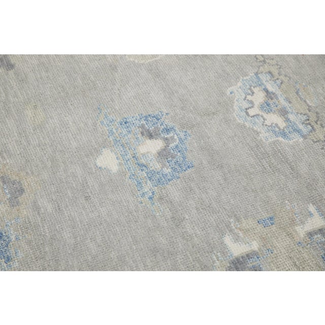 This modern Turkish Oushak rug is a stunning piece of art that has been handwoven using traditional techniques by skilled...