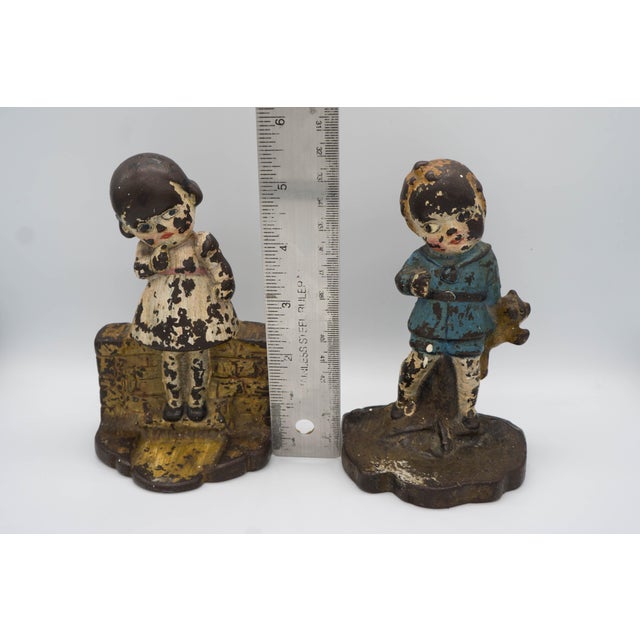 A pair of antique cast iron door stops or book ends with original, detailed hand painting. The bases are marked but has...