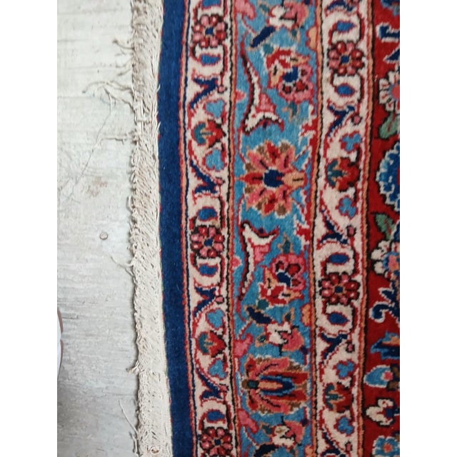 Vintage Persian Kashan rug featuring a deep navy field anchored by an elaborate central medallion in shades of rust,...