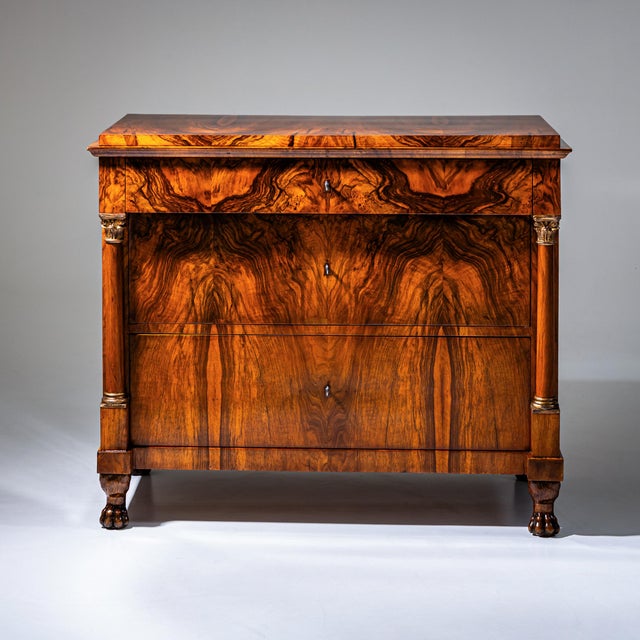 Biedermeier chest of drawers with three drawers and side columns with gilt-patinated capitals and bases. The chest rests...
