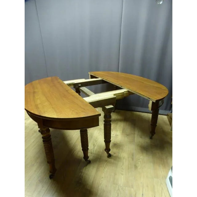 Very large oval table with 8 legs in walnut with a XIXth century band, this table has 6 extensions, one of which has a...