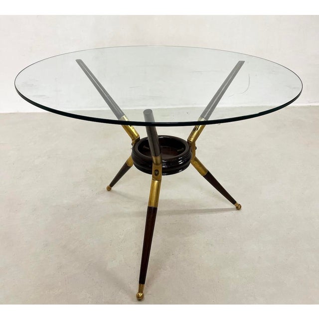 Unique 1950s Cesare Lacca-style coffee table with a three-legged frame made of black ebonized wood and brass, featuring a...