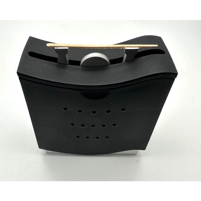 The little “weight lifter” in Menu's toothpick dispenser holds up a clean toothpick in his outstretched arms every time...