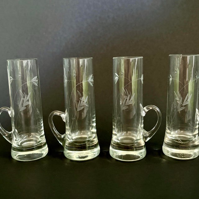 Charming set of 4 vintage hand-blown shot glasses featuring delicate etched leaf detailing and a unique low side handle...