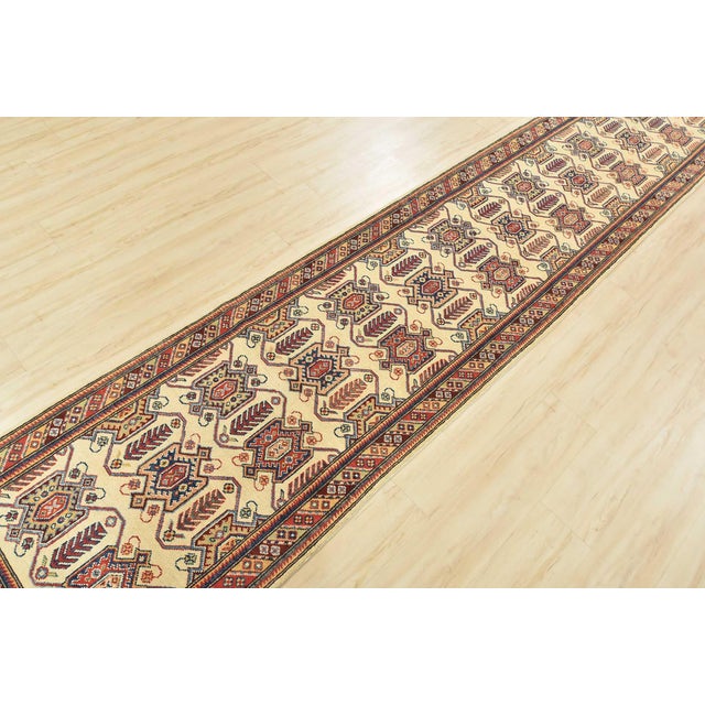 This traditional tribal geometric Caucasian Kazak runner is hand-knotted with an all-wool pile on a cotton foundation....