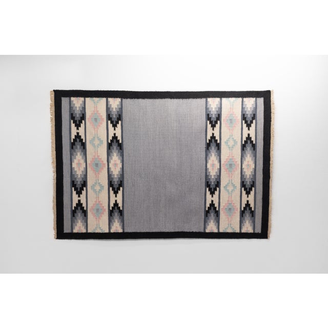 Mid-Century Swedish Kilim in Tones of Grey with a plain central motif and geometric patterned fringes. Sweden circa 1960....