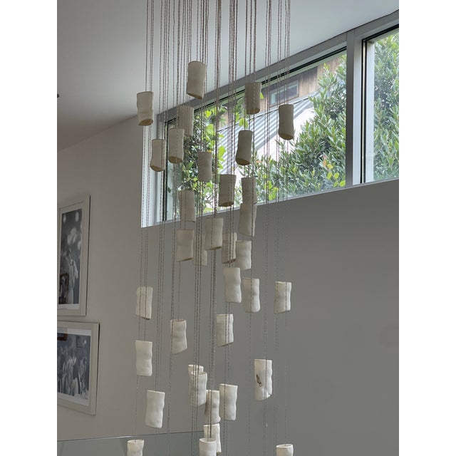 White pendant lighting for staircase or dining room lighting. Amorphic Porcelain style.. This whimsical staggering pendant...