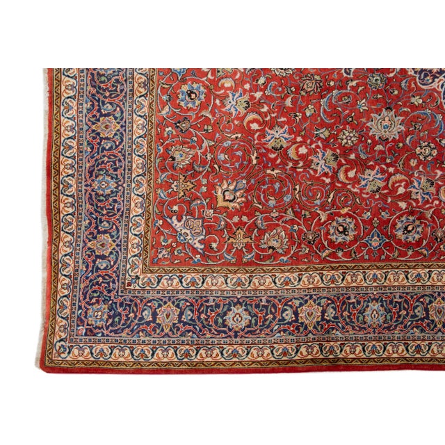 This is a classic Persian Kerman rug featuring a red base. It is further adorned with accents in various colors, all...