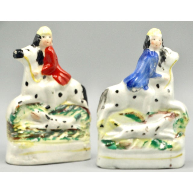 Petite pair of 19th-Century English Staffordshire flat back mantel pair of figurines. They each depict a child equine...