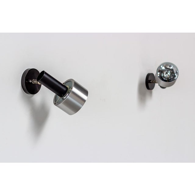 Pair of black cylinder spot lights or sconces, circa 1970. Black metal tube and brushed aluminum shade with mirrored...