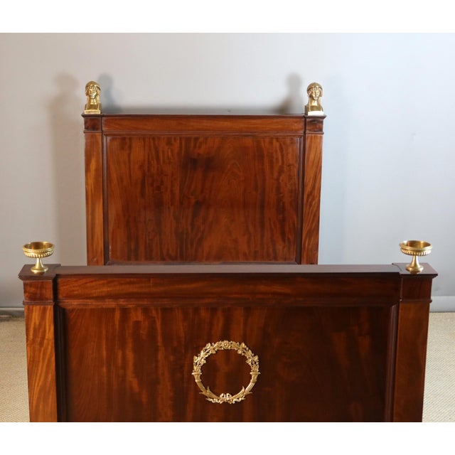 Empire period bed, fully restored and finished with a traditional French polish. Beautiful gilt bronze ornamentation...