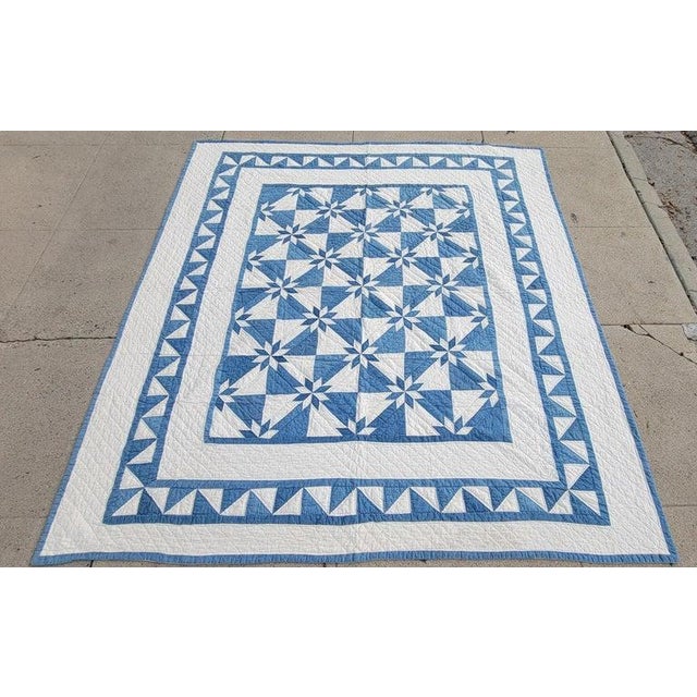 1920s blue and white contained eight point star with and hourglass variation to the design. the blue Border is a jigsaw...