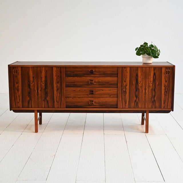 Rosewood sideboard with sliding doors and central drawers. Designed by Erik Wörtz, 1960s. The "Ladoga" sideboard, designed...