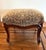 Charming vintage footstool ottoman featuring a generously cushioned tapestry-upholstered top in warm shades of cream,...