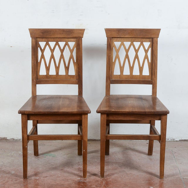 This pair of vintage solid wood chairs strikes a perfect balance between structural solidity and geometric elegance,...