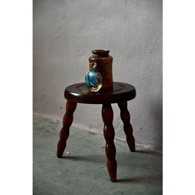 Made entirely of wood, this rustic stool looks like it came straight from a farmhouse or mountain chalet. The tripod legs...
