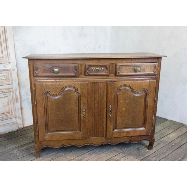 This beautiful French Provincial Louis XV oak buffet still has its original old wax patina and brass hardware and it has...