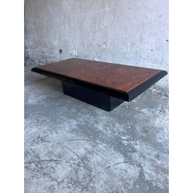 This striking vintage coffee table combines the warm, expressive character of burl wood veneer with a bold black lacquered...