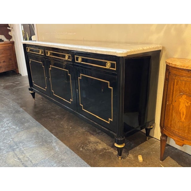 The Louis XVI Style Piano Black Sideboard with a Marble Top is a luxurious and elegant piece of furniture. Featuring a...