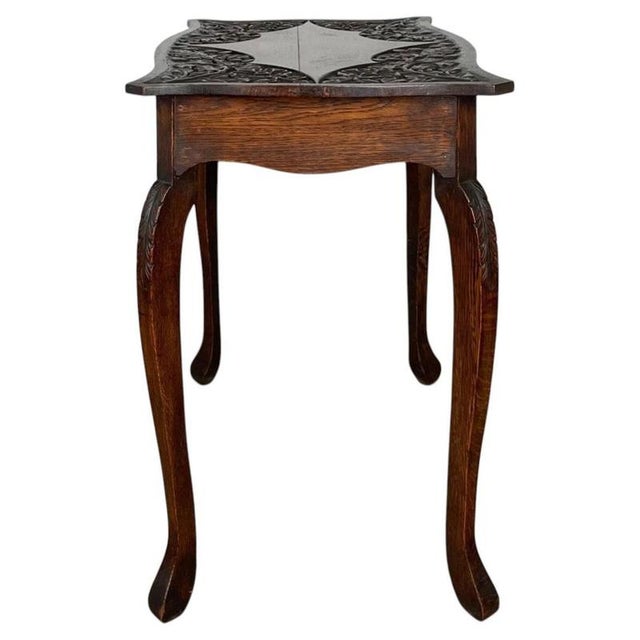 A beautifully crafted Edwardian side table, expertly made from oak and featuring an exceptional carved decorative top with...