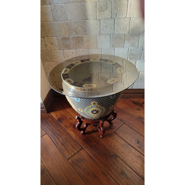 A captivating fusion of artistry and utility, this decorative side table features a large, hand-painted ceramic vessel...