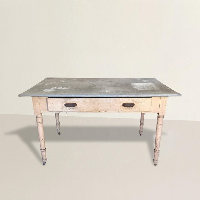 This late 19th-century American garden table refuses polish in favor of presence. The zinc top—softly dimpled, mottled,...