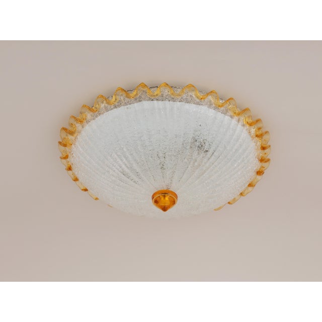 Beautiful ocher yellow and clear ice glass flush mount. Made by Barovier and Toso around the 1970s in Italy. The lamp...