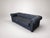 A dark charcoal Chesterfield-style sofa with classic deep tufting, rolled arms, nailhead trim, and a strong sculptural...