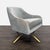 This West Elm lounge chair features a soft gray velvet upholstery and a sleek gold metal base. The chair has a modern...