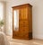 A late Victorian walnut compactum wardrobe with a shaped cornice, full-length mirrored door and decorative panelled...