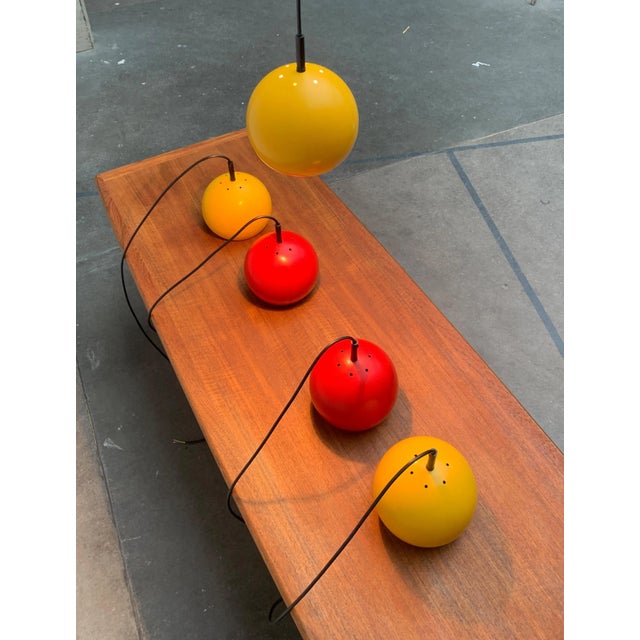 Mid Century ball pendant lights in red and yellow. A classic design in a special color. The lampshades form simple spheres...