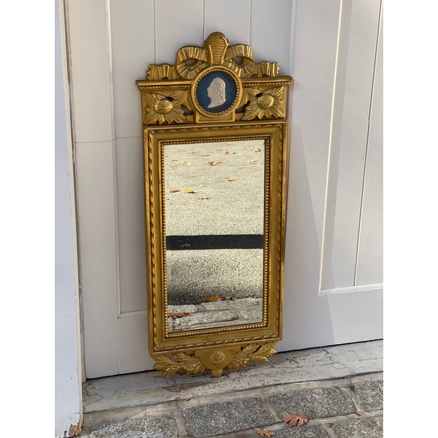 A vintage Gustavian style gilt wood rectangular wall mirror with a beveled mirror plate, beaded and rope-twist gilt frame,...