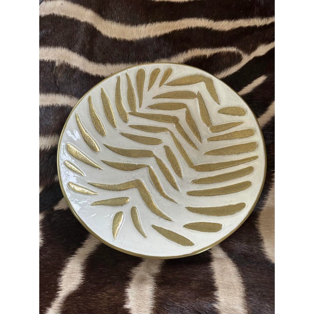 Fabulous enameled metal decorative plate, dating to the 1980’s. Off-white and gold enamel featuring an organic palm leaf...